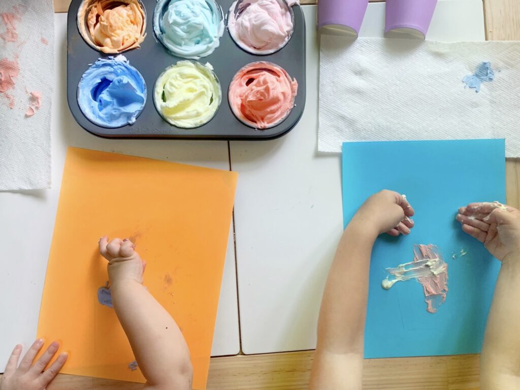 Preschoolers working on puffy paint mixed-media gelati process art paintings